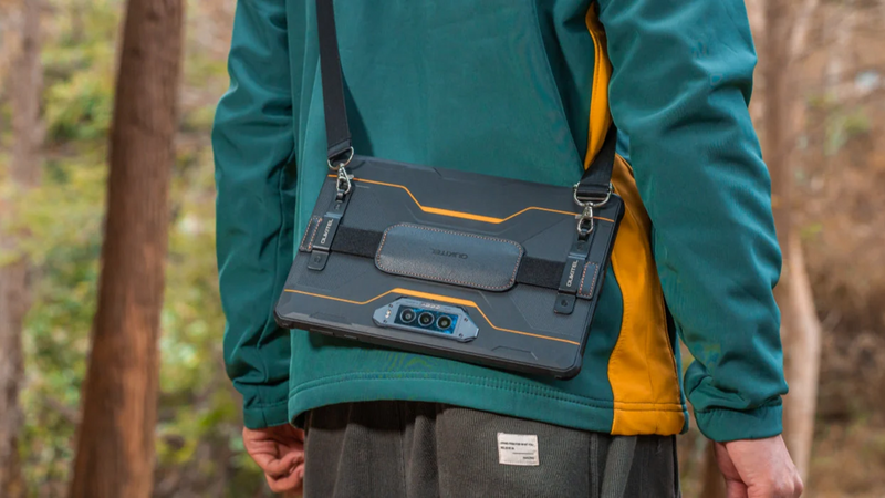 OUKITEL rugged tablet carried with a shoulder strap during an outdoor forest hike