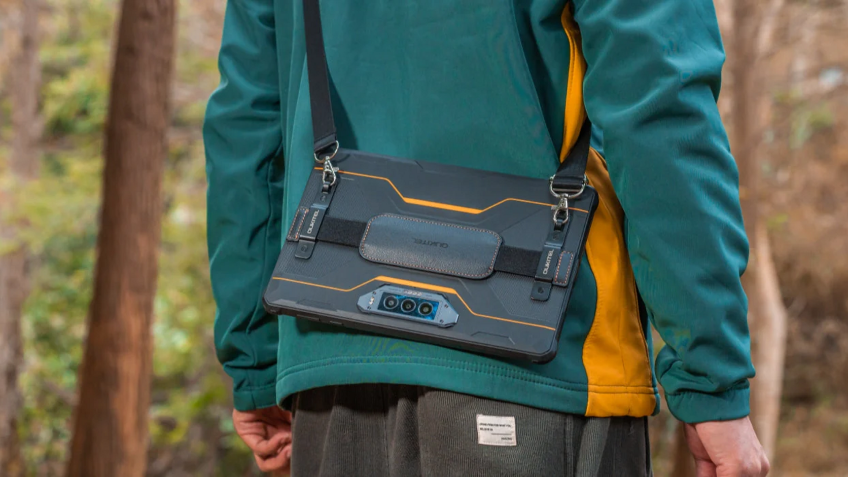 OUKITEL rugged tablet carried with a shoulder strap during an outdoor forest hike